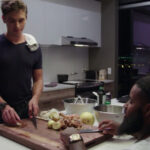 Antoni Porowski standing at a cutting board with Wesley Hamilton across from him in his wheelchair; both cutting vegetables.